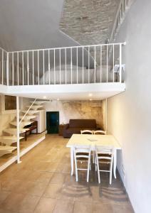 un soggiorno con letto a soppalco, tavolo e sedie di Casa Flavia a Ostuni
