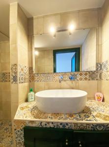 bagno con grande lavandino e specchio di Casa Flavia a Ostuni