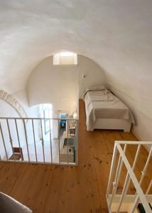 una camera da letto con un letto e una scala in una stanza di Casa Flavia a Ostuni