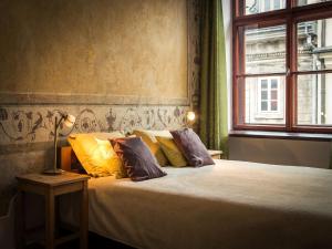 Un dormitorio con una cama con almohadas amarillas y una ventana en Nicholas Studio, en Cracovia