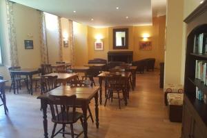 un ristorante con tavoli e sedie in legno e un pianoforte di NOUVEAU ! MAGNIFIQUE T2 FACE AUX THERMES ad Aulus-les-Bains
