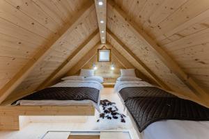 2 camas en el ático de una cabaña de madera en Alpine Chalet Velika Planina - Irenca - I Feel Alps, en Stahovica
