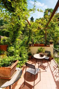 patio ze stołem, krzesłami i drzewami w obiekcie Casa Quaratesi we Florencji