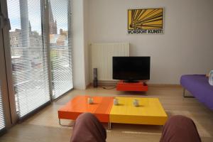 een woonkamer met een salontafel en een televisie bij Sfeervol rustige loft in Oostende