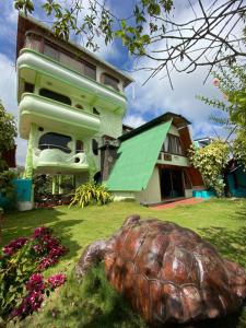 a house with a turtle statue in front of it at Hostal Casa Edén in Puerto Ayora