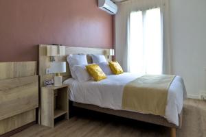 a bedroom with a large bed with yellow pillows at Hôtel du Golfe Sete-Balaruc in Balaruc-les-Bains +33 photos