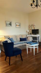 uma sala de estar com um sofá e uma mesa em Le Cottage de la Plage - 2ch, 2 SDB - Terrasse - Déco de charme - 500m plage em Cabourg