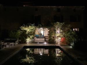 a pool in front of a building at night at Mas Renard in Beauvoisin