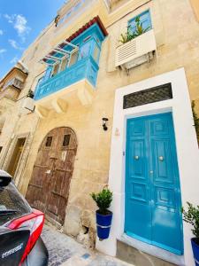 eine blaue Tür auf einem Gebäude mit einem Haus in der Unterkunft Maltese town house in Valletta