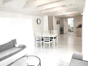 a white living room with a table and chairs at Sun&Sea in Jastarnia