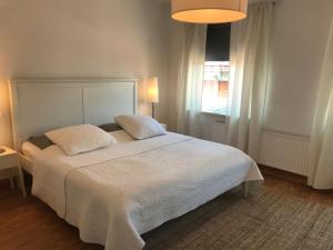 Un dormitorio con una gran cama blanca y una ventana en Wohnung Bel Etage im historischen Amtshaus en Fehmarn