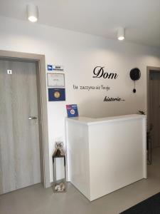 a lobby with a white counter with a sign on the wall at Sun&Sea in Jastarnia