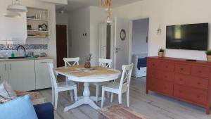 a kitchen and dining room with a table and chairs at apartament Łebska Ostoja in Żarnowska