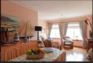 una sala de estar con una mesa con un bol de fruta en Aguda Beachfront Apartment en Aguda
