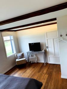 a bedroom with a television and a desk with a window at Grand Guesthouse Gardakot in Gardakot