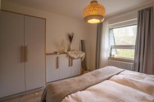a bedroom with a bed and a window and a chandelier at Waldrausch Titisee in Titisee-Neustadt