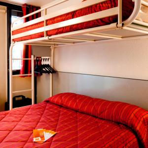 a bedroom with a bed with a red comforter at Premiere Classe Boissy St Leger in Boissy-Saint-Léger