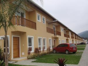 une voiture rouge garée devant un bâtiment dans l'établissement Casa em condomínio fechado, com piscina privativa em Juquehy, à São Sebastião