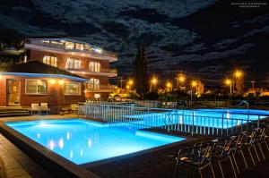 a large swimming pool with chairs in front of a building at Ionion Star Hotel in Preveza