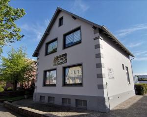 a white house with black windows at Steinmarner Bude 2 in Cuxhaven