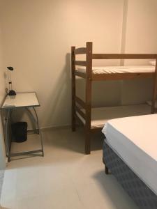 Cette chambre comprend des lits superposés, une table et une chaise. dans l'établissement Kitnet na Boa Vista, Recife - 508, à Récife