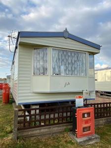 una casa móvil está sentada en una valla en G4 Holiday Caravan en Par
