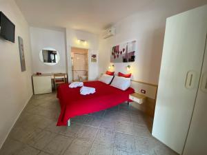 ein Schlafzimmer mit einem roten Bett in einem Zimmer in der Unterkunft B&B Petite Maison in Posada