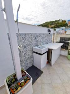 uma cozinha branca com um lavatório e um balcão em Maridea - Madreperla em Ponza