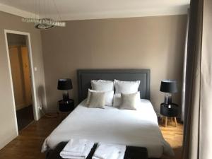 a bedroom with a large bed with white sheets and pillows at Spacieux T3 en hyper centre in Quimper