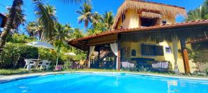 a house with a swimming pool in front of a house at Pousada Vila Mato Verde in Morro de São Paulo