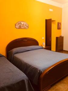ein Schlafzimmer mit einem Bett und einer gelben Wand in der Unterkunft One bedroom appartement at Santa Maria di Castellabate 200 m away from the beach with sea view enclosed garden and wifi in Santa Maria di Castellabate