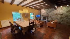 a dining room with a table and a stone wall at La Borda del Tío Nicolás - Selva de Irati in Aribe