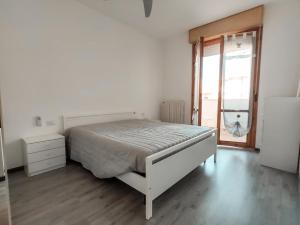 Habitación blanca con cama y ventana en Finestra sul mare en Lido di Fermo