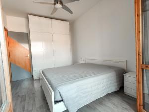 a white bedroom with a bed and a ceiling fan at Finestra sul mare in Lido di Fermo +7 photos