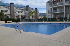a swimming pool in front of some apartment buildings at Enjoy Denia in Denia
