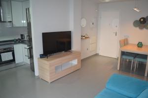 a living room with a flat screen tv on a wooden entertainment center at Enjoy Denia in Denia