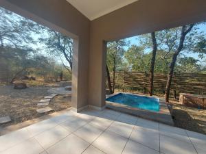 a swimming pool in a house with a large window at 3714 @Ribbok in Marloth Park