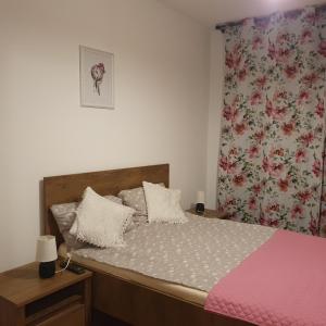 a bedroom with a large bed with a pink blanket at Forest Apartment Timișoara in Timişoara