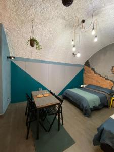 1 Schlafzimmer mit einem Bett und einem Tisch sowie einem Bett und einem m2 in der Unterkunft Casa Velata a Spaccanapoli in Neapel