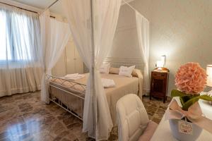 een slaapkamer met een bed met gordijnen en een tafel bij NONNA VALERIA in Diso