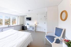 sypialnia z łóżkiem, 2 krzesłami i biurkiem w obiekcie Hotel Pepita w mieście Allinge