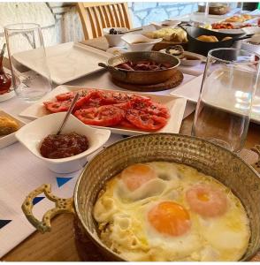 a table with a bowl of eggs and other food at The White Hotel Alaçatı in Alaçatı