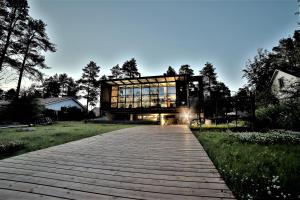 a glass house with a wooden walkway at Oulu Loft Guesthouse in Oulu