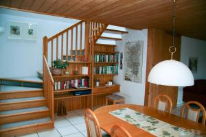 a dining room with a table and a book shelf at Haus Klebern, Egg - im Zentrum des Bregenzerwaldes in Egg