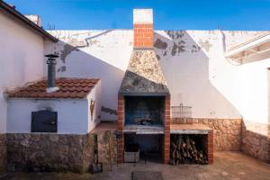 una chimenea en un edificio con horno de pizza en CASA RURAL ADELA, en Odón