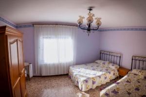 Un dormitorio con dos camas y una ventana. en CASA RURAL ADELA, en Odón