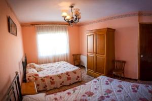 Un dormitorio con dos camas y una ventana. en CASA RURAL ADELA, en Odón