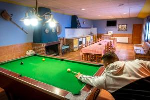 un homme jouant au billard dans une salle avec un billard dans l'établissement CASA RURAL ADELA, 