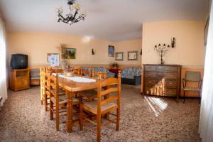 Un comedor con una mesa y sillas y un sofá. en CASA RURAL ADELA, en Odón