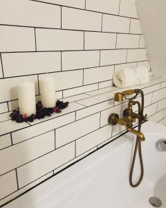 a bath tub with candles on a white tiled wall at Siedlisko Besarabka in Czernikowo